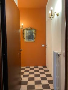 un couloir avec un mur orange et un sol en damier dans l'établissement La Marina di Milano - Pier Lombardo, à Milan
