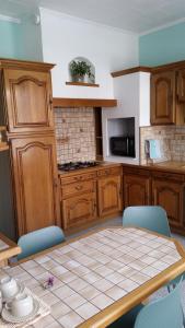 a kitchen with a table with blue chairs and a counter at STADE OLYMPIQUE A PIED Colombes Parking jardin Wifi in Colombes