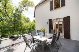 a patio with a table and chairs on a balcony at Landhaus Karbach komplett oder einzelne Wohneinheiten Villa inkl Sauna bzw Waldhäuschen in Hirten