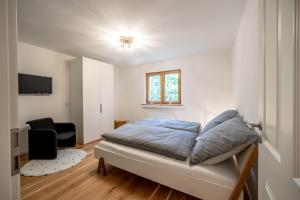 a bedroom with a bed and a chair in it at Landhaus Karbach komplett oder einzelne Wohneinheiten Villa inkl Sauna bzw Waldhäuschen in Hirten