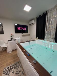 ein großer Whirlpool in einem Zimmer mit einem TV in der Unterkunft Love Room à Cannes - Appartement 25m2 pour 2 personnes avec un jacuzzi Privé in Cannes