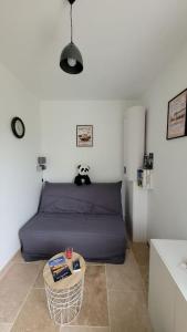 een slaapkamer met een paars bed en een tafel bij Studio Cosy in Nazelles