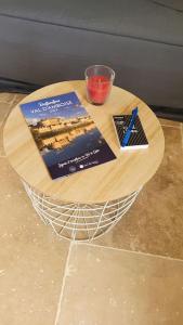 a wooden table with a book and a cup on it at Studio Cosy in Nazelles