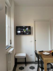 Habitación con mesa y TV en la pared. en La Marina di Milano - Pier Lombardo, en Milán