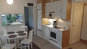kuchnia z małym stołem i kuchnia z białymi szafkami w obiekcie Apartments Golf w mieście Tahkovuori