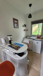 a kitchen with a table and a counter with chairs at Studio Cosy in Nazelles