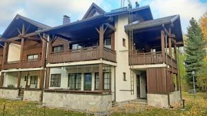 Una casa grande con balcones de madera. en Apartments Golf, en Tahkovuori