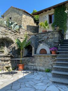 una casa de piedra con horno de piedra y escaleras en Relais San Filippo in Sogaglia, en Mulazzo