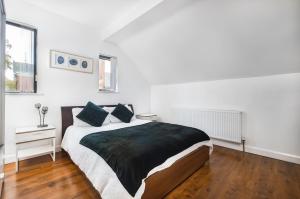 a bedroom with a large bed in a white room at Meersbrook Luxury Duplex Apartment in Sheffield