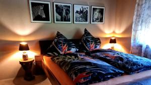 een slaapkamer met een bed met kussens en foto's aan de muur bij Gasthaus Paula in Üdersdorf