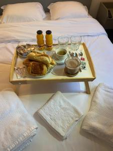 ein Tablett mit Essen auf einem Tisch auf einem Bett in der Unterkunft HOTEL DU CENTRE in Roubaix