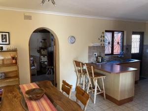 a kitchen with a wooden table and a kitchen with a counter at Paradise in Kommetjie in Cape Town +11 photos