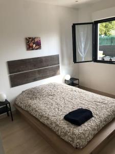 sypialnia z łóżkiem i oknem w obiekcie Charment logement avec parking et jardin privatif w mieście Rocbaron