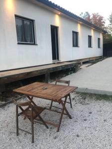 drewniany stół i krzesło przed budynkiem w obiekcie Charment logement avec parking et jardin privatif w mieście Rocbaron