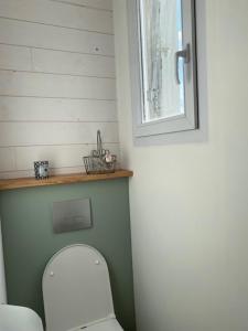 a small bathroom with a toilet and a window at CHEZ ROZ in Rostrenen