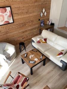 a living room with a white couch and a coffee table at CHEZ ROZ in Rostrenen