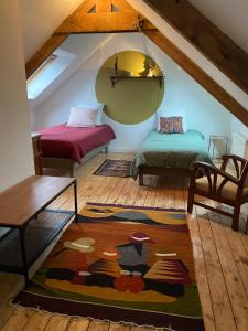 a attic room with two beds and a rug at CHEZ ROZ in Rostrenen