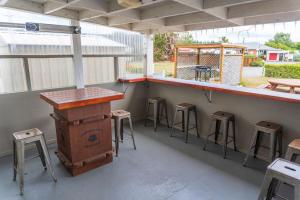 d'une terrasse avec un bar avec des tabourets et un comptoir. dans l'établissement Leithfield Beach Holiday Park, à Leithfield