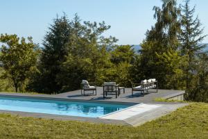 uma piscina com cadeiras e uma mesa ao lado em Domaine Mont-Riant à Jurançon em Jurançon