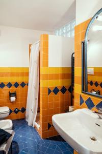 y baño con azulejos de color naranja y azul y lavabo. en Un posto davvero unico! en Marone