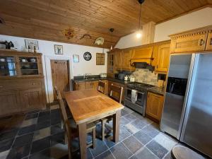 cocina con mesa de madera y nevera de acero inoxidable en John the mills cottage spaHot tub private beach en Donegal