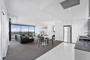 a kitchen and living room with a couch and a table at Circle on Cavill - HR Surfers Paradise in Gold Coast