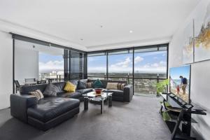 a living room with a couch and a table at Circle on Cavill - HR Surfers Paradise in Gold Coast