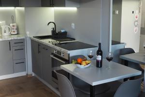 a kitchen with a table with a bowl of fruit and wine glasses at Apartament Orla 47F Perłowa Dolina in Bydgoszcz