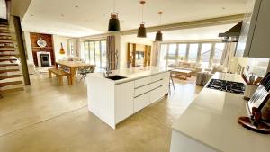 a kitchen with white cabinets and a living room at No2 Merlot in Cape Town