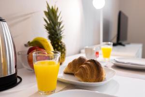 a table with a plate of bread and a glass of orange juice at 4flats in Maribor