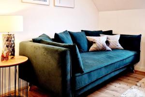 Stilvolle Maisonette Wohnung في كارلسروه: أريكة زرقاء في غرفة المعيشة مع طاولة