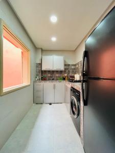 馬拉喀什的住宿－Appartement avec jolie terrasse privée et parking Apartment with nice private terrace and parking，带冰箱和洗碗机的厨房