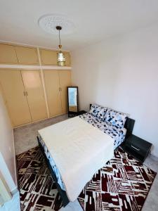 een slaapkamer met een bed en een tapijt bij Appartement avec jolie terrasse privée et parking Apartment with nice private terrace and parking in Marrakesh