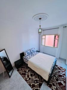 een slaapkamer met een bed en een tapijt bij Appartement avec jolie terrasse privée et parking Apartment with nice private terrace and parking in Marrakesh