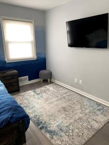a bedroom with a bed and a flat screen tv at Fabulous Family Rancher ! Ocean City NJ Beaches in Somers Point