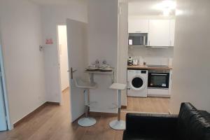 a living room with a couch and a kitchen at Appart Cosy Auber Porte de Paris in Aubervilliers