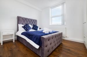 a bedroom with a large bed with blue sheets and a window at Meersbrook Luxury 2 Bedroom Apartment in Sheffield