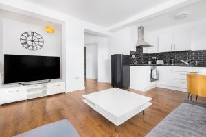 a white living room with a large tv and a table at Meersbrook Luxury 2 Bedroom Apartment in Sheffield +14 photos