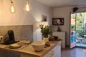 a kitchen with a table with plates and wine glasses at Studio meublé en face du golf côté piscine in Mouans-Sartoux