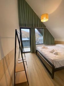 una camera da letto con un letto con una scala e finestre di Kazbegi View Cottages a Kazbegi Altre 25 foto