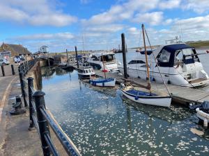 a group of boats docked at a dock in the water at Jolly Sailors Retreat in Wells next the Sea