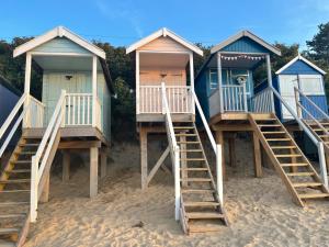a row of beach huts on a sandy beach at Jolly Sailors Retreat in Wells next the Sea