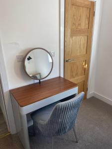 a dressing table with a mirror and a chair at Jolly Sailors Retreat in Wells next the Sea