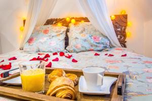 a tray with food and drinks on a bed at Jacuzzi® - La petite Romantique - FloBNB in Laon
