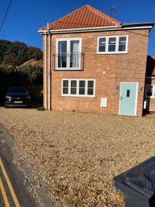 a brick house with a car parked in the driveway at Jolly Sailors Retreat in Wells next the Sea