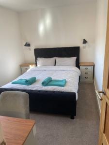een slaapkamer met een groot bed met twee blauwe handvatten bij Jolly Sailors Retreat in Wells next the Sea
