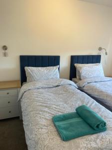 a bed with a green pillow on top of it at Jolly Sailors Retreat in Wells next the Sea