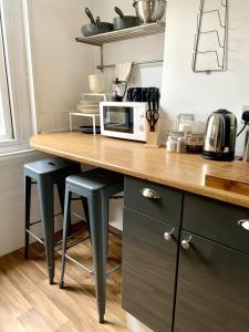 a kitchen with a counter with stools and a microwave at Seaview Richmond Terrace in Swansea