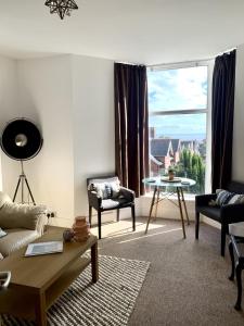 a living room with a couch and a table and a window at Seaview Richmond Terrace in Swansea