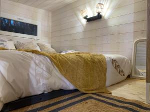 Un dormitorio con una cama con una manta. en La Cabane de Piquet, en Le Tablier